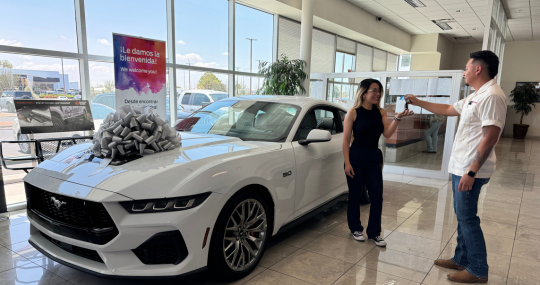 Woman getting keys to new car purchase