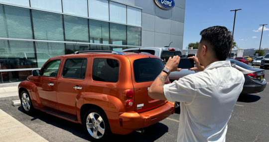 Man taking photo of car for trade in value offer